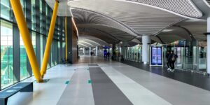 A modern, accessible airport lounge with wide paths and inclusive seating for senior travelers.