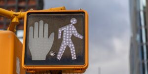 Modern urban crosswalk with pedestrian signal and older adults crossing safely.
