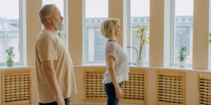 A healthy senior practicing good posture in a bright living room.
